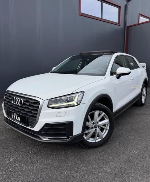 White Audi Q2 SUV parked indoors, front three-quarter view with LED headlights and alloy wheels visible