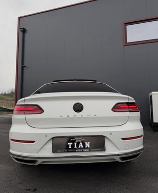 Rear view of a white Volkswagen Arteon sedan with red taillights and Titan auto dealership license plate