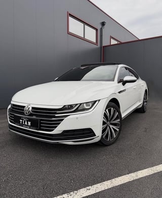 White Volkswagen Titan sedan parked in a modern garage with gray walls and industrial windows