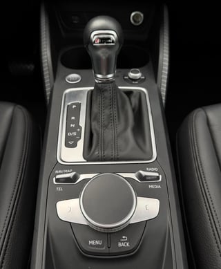 Close-up of car center console with automatic transmission shifter and infotainment control knob