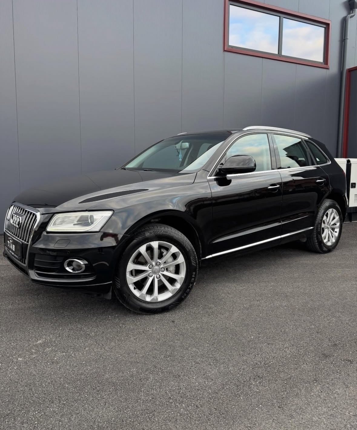 Black Audi Q5 SUV parked in front of building