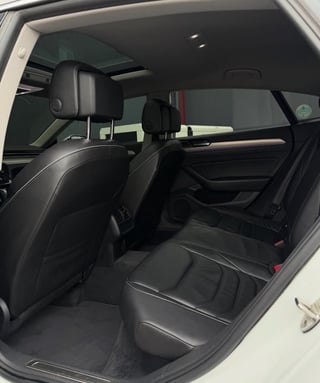 Interior view of a cars rear seating area with black leather seats and headrests