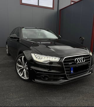 Black Audi sedan parked in garage with LED headlights and alloy wheels